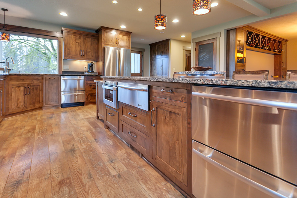 Large transitional l-shaped light wood floor eat-in kitchen photo in Portland with an undermount sink, shaker cabinets, medium tone wood cabinets, marble countertops, gray backsplash, stone slab backsplash, stainless steel appliances and an island