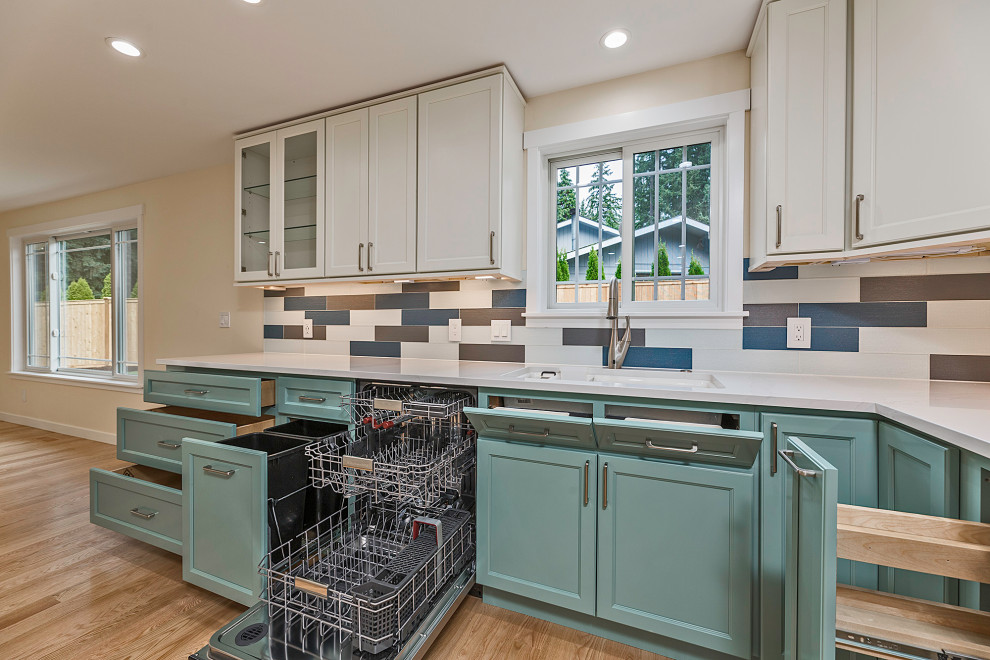 Bild på ett stort funkis flerfärgad flerfärgat kök, med en undermonterad diskho, luckor med upphöjd panel, turkosa skåp, bänkskiva i kvarts, flerfärgad stänkskydd, stänkskydd i glaskakel, rostfria vitvaror, ljust trägolv och en halv köksö