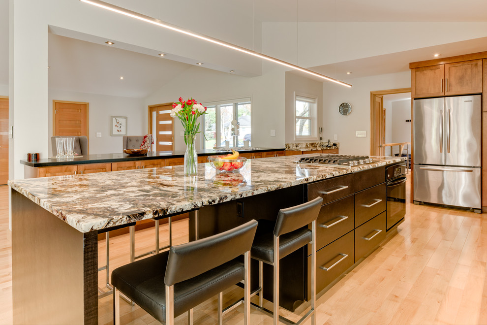 Inspiration for a large modern galley light wood floor eat-in kitchen remodel in Columbus with an undermount sink, shaker cabinets, medium tone wood cabinets, granite countertops, multicolored backsplash, stone slab backsplash, stainless steel appliances and an island