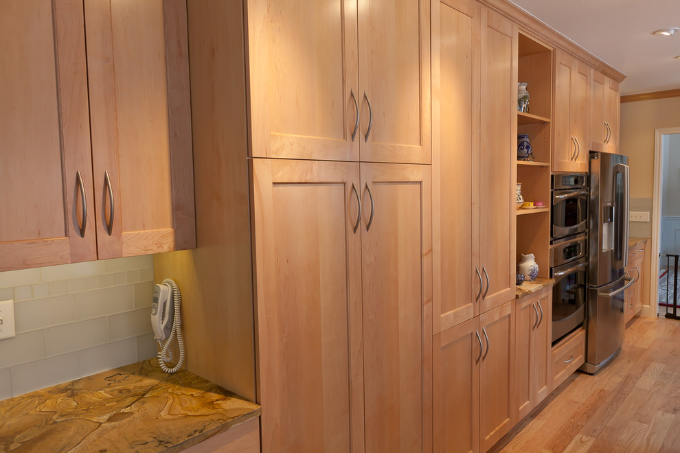 Exempel på ett mellanstort klassiskt kök, med en undermonterad diskho, skåp i shakerstil, skåp i ljust trä, bänkskiva i onyx, vitt stänkskydd, stänkskydd i tunnelbanekakel, rostfria vitvaror och ljust trägolv