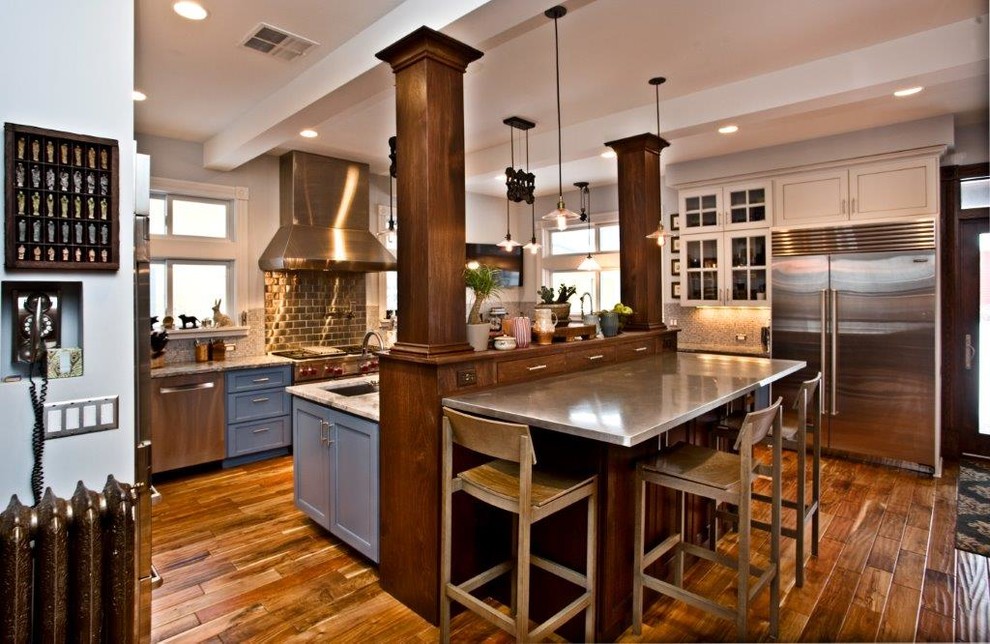 Example of a large arts and crafts u-shaped medium tone wood floor and brown floor open concept kitchen design in Minneapolis with an undermount sink, shaker cabinets, blue cabinets, copper countertops, metallic backsplash, metal backsplash, stainless steel appliances and an island