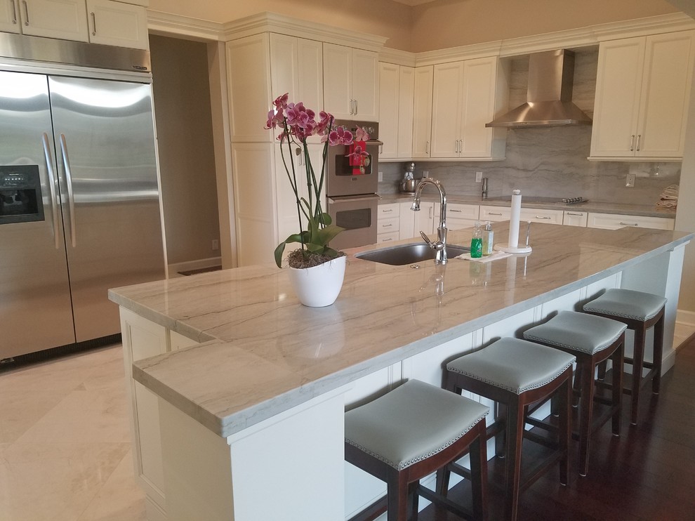 Open concept kitchen - large transitional u-shaped marble floor and beige floor open concept kitchen idea in Miami with an undermount sink, shaker cabinets, white cabinets, quartzite countertops, gray backsplash, stainless steel appliances and an island