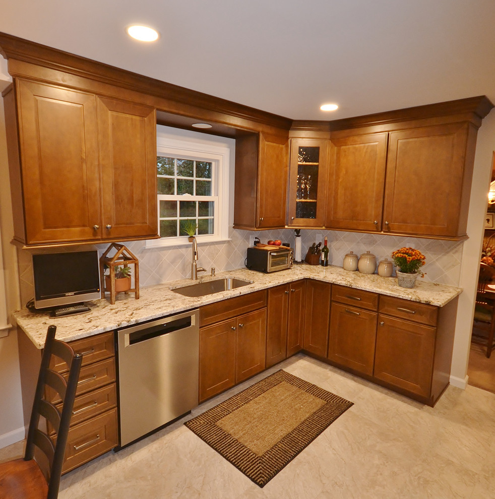 Mid-sized transitional l-shaped vinyl floor and beige floor eat-in kitchen photo in Philadelphia with an undermount sink, raised-panel cabinets, medium tone wood cabinets, granite countertops, beige backsplash, ceramic backsplash, stainless steel appliances and multicolored countertops