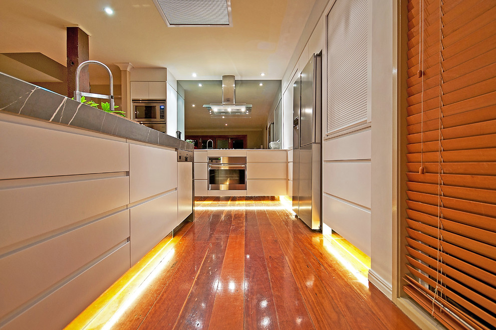 Immagine di una grande cucina contemporanea con lavello da incasso, ante beige, top in marmo, elettrodomestici in acciaio inossidabile e pavimento in legno massello medio