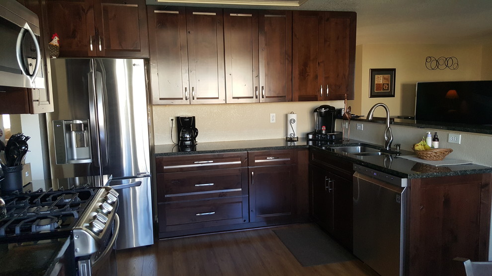 Inspiration for a medium sized classic l-shaped enclosed kitchen in Denver with a double-bowl sink, shaker cabinets, dark wood cabinets, granite worktops, stainless steel appliances and no island.