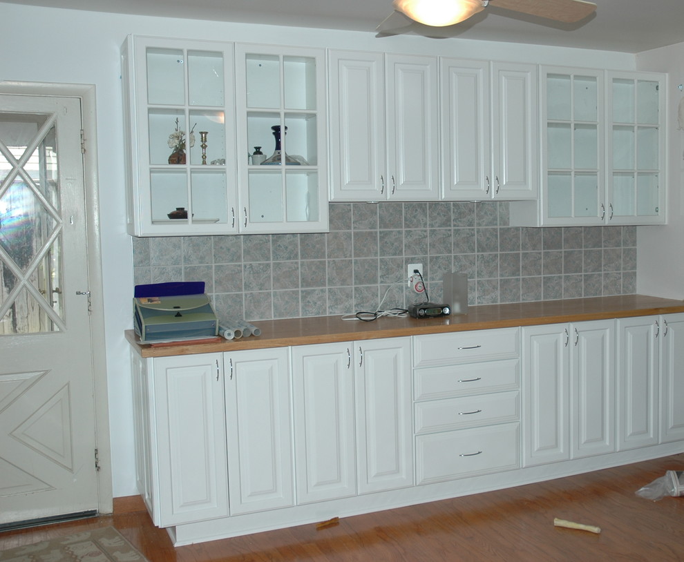Photo of a medium sized modern u-shaped kitchen/diner in DC Metro with a submerged sink, white cabinets, stainless steel appliances and ceramic flooring.