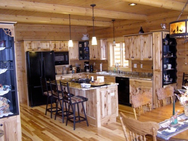 Réalisation d'une cuisine chalet en bois clair de taille moyenne avec un placard avec porte à panneau surélevé, un plan de travail en granite, un sol en bois brun et îlot.