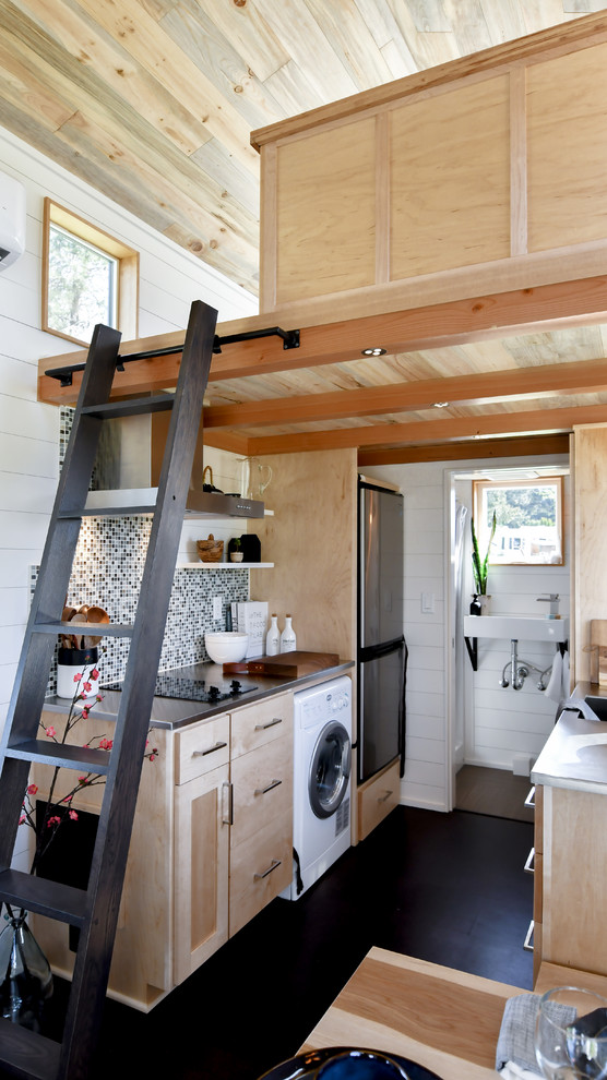 Стильный дизайн: параллельная кухня-гостиная со стиральной машиной в стиле рустика с плоскими фасадами, светлыми деревянными фасадами, разноцветным фартуком, фартуком из плитки мозаики, черным полом и серой столешницей - последний тренд