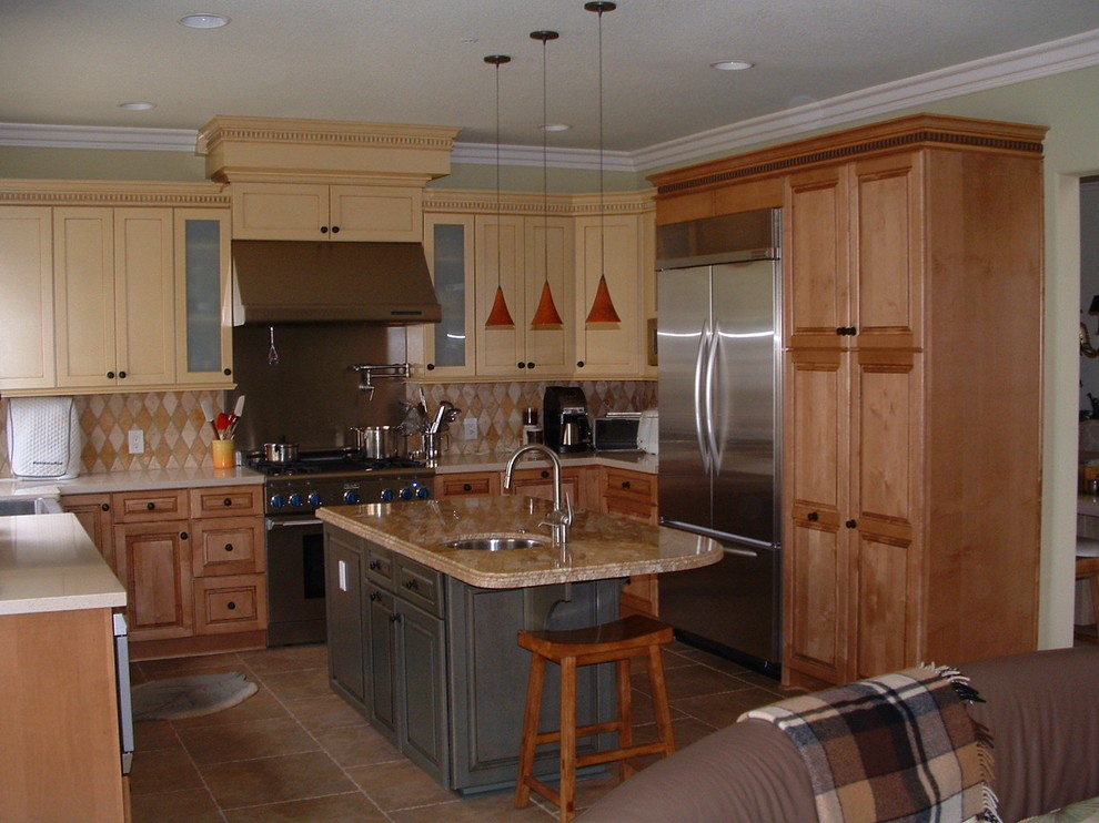 Inredning av ett klassiskt mellanstort kök, med en rustik diskho, skåp i shakerstil, gula skåp, bänkskiva i kvarts, flerfärgad stänkskydd, stänkskydd i stenkakel, rostfria vitvaror, travertin golv och en köksö