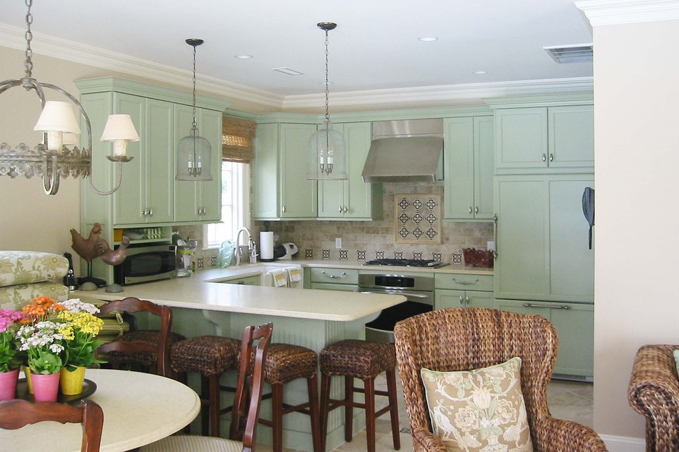 Пример оригинального дизайна: п-образная кухня в классическом стиле с фасадами в стиле шейкер, зелеными фасадами, разноцветным фартуком, техникой под мебельный фасад и барной стойкой
