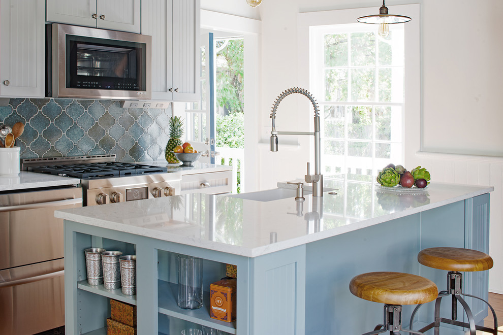 Small farmhouse galley medium tone wood floor and brown floor kitchen photo in Other with a farmhouse sink, shaker cabinets, gray cabinets, quartz countertops, blue backsplash, terra-cotta backsplash, stainless steel appliances, an island and white countertops