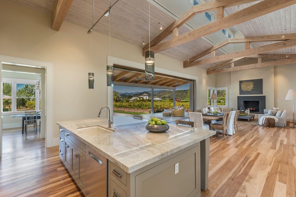 Inspiration for a country galley kitchen in San Francisco with a submerged sink, shaker cabinets, white cabinets, brown splashback, integrated appliances, medium hardwood flooring, an island and brown floors.