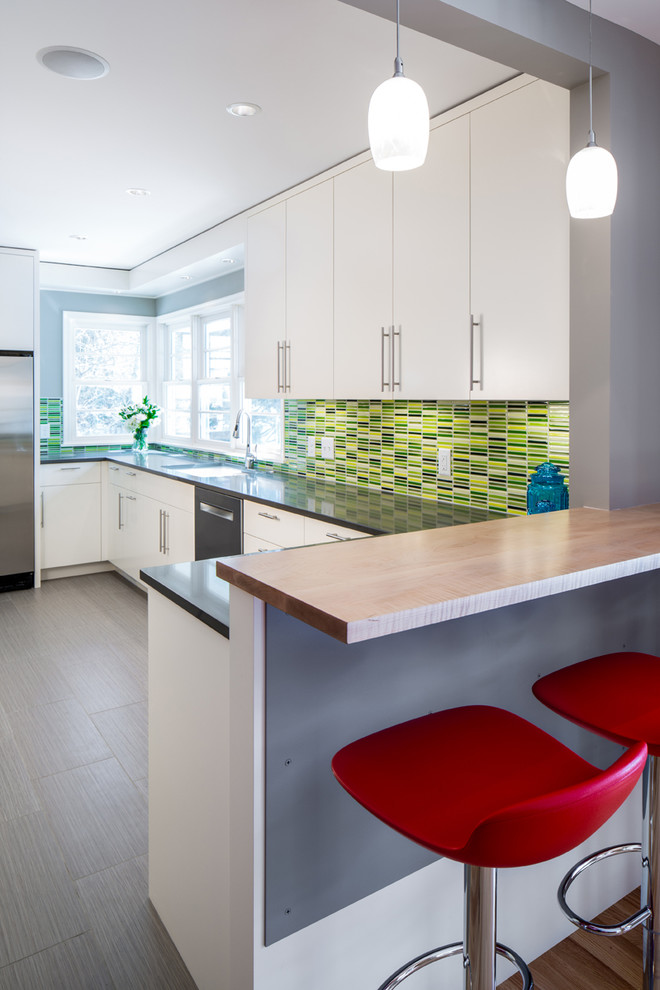 Photo of a contemporary kitchen in Minneapolis with a submerged sink, flat-panel cabinets, white cabinets, composite countertops, green splashback, porcelain splashback, stainless steel appliances, porcelain flooring and no island.