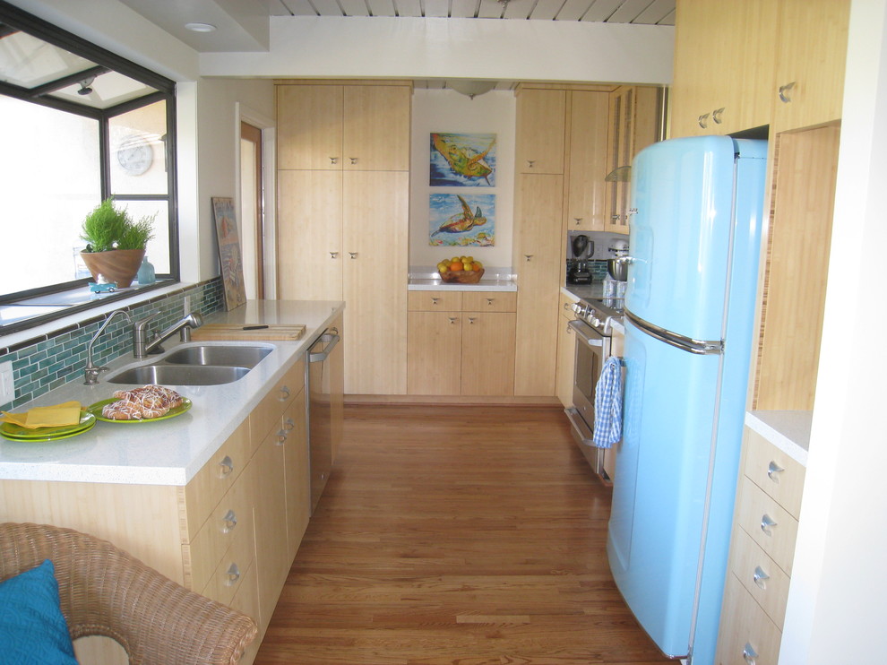 Ejemplo de cocina actual cerrada con fregadero de doble seno, armarios con paneles lisos, puertas de armario de madera clara, electrodomésticos de colores y salpicadero azul