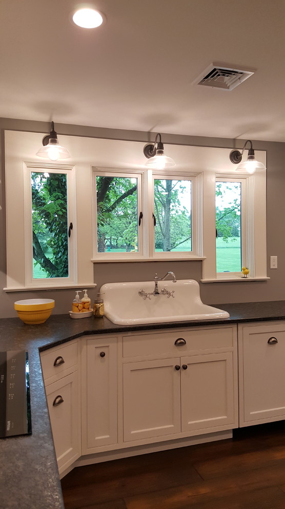 Photo of a medium sized bohemian l-shaped kitchen/diner in Philadelphia with a belfast sink, beaded cabinets, white cabinets, granite worktops, stainless steel appliances, dark hardwood flooring and an island.