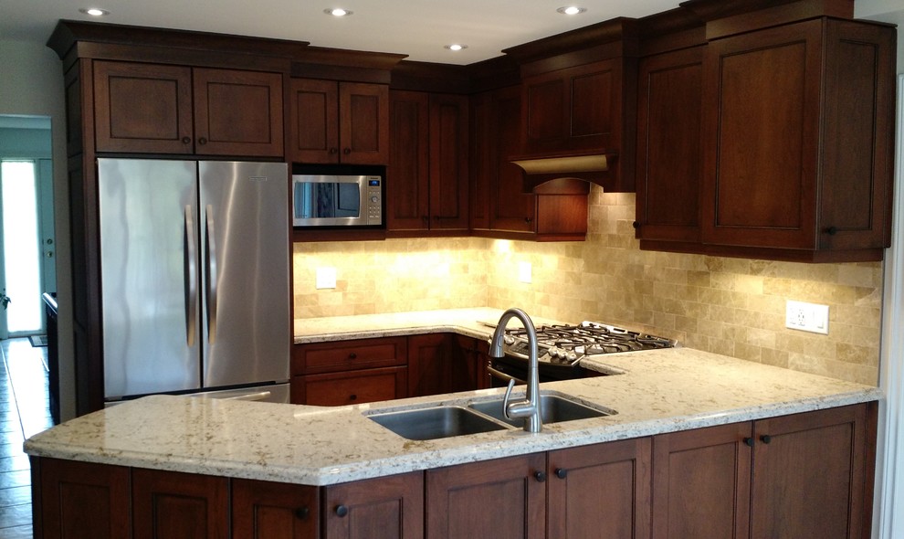 This is an example of a small classic l-shaped kitchen/diner in Toronto with a submerged sink, shaker cabinets, medium wood cabinets, composite countertops, stone tiled splashback, stainless steel appliances, ceramic flooring and a breakfast bar.