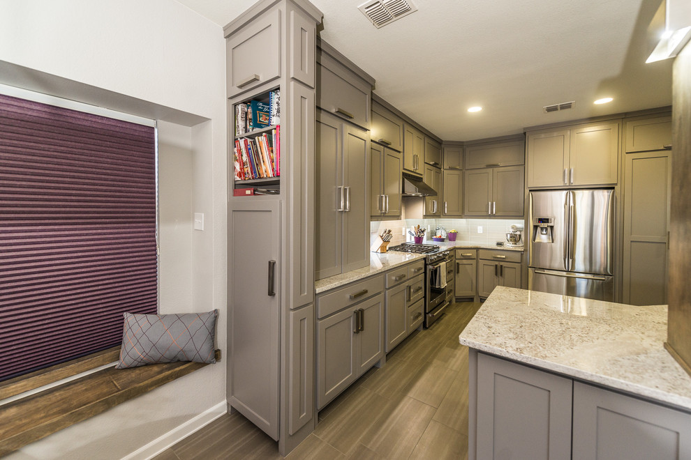 Photo of a modern kitchen in Dallas with a single-bowl sink, flat-panel cabinets, grey cabinets, granite worktops, grey splashback, ceramic splashback, stainless steel appliances and porcelain flooring.