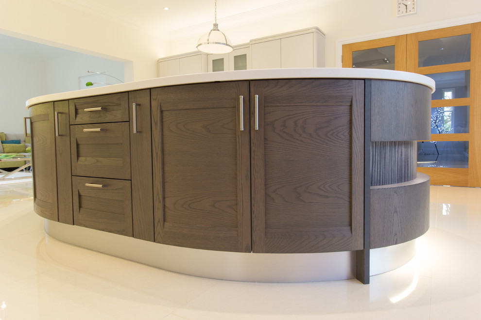 Design ideas for a classic open plan kitchen in Essex with grey cabinets, glass sheet splashback and an island.