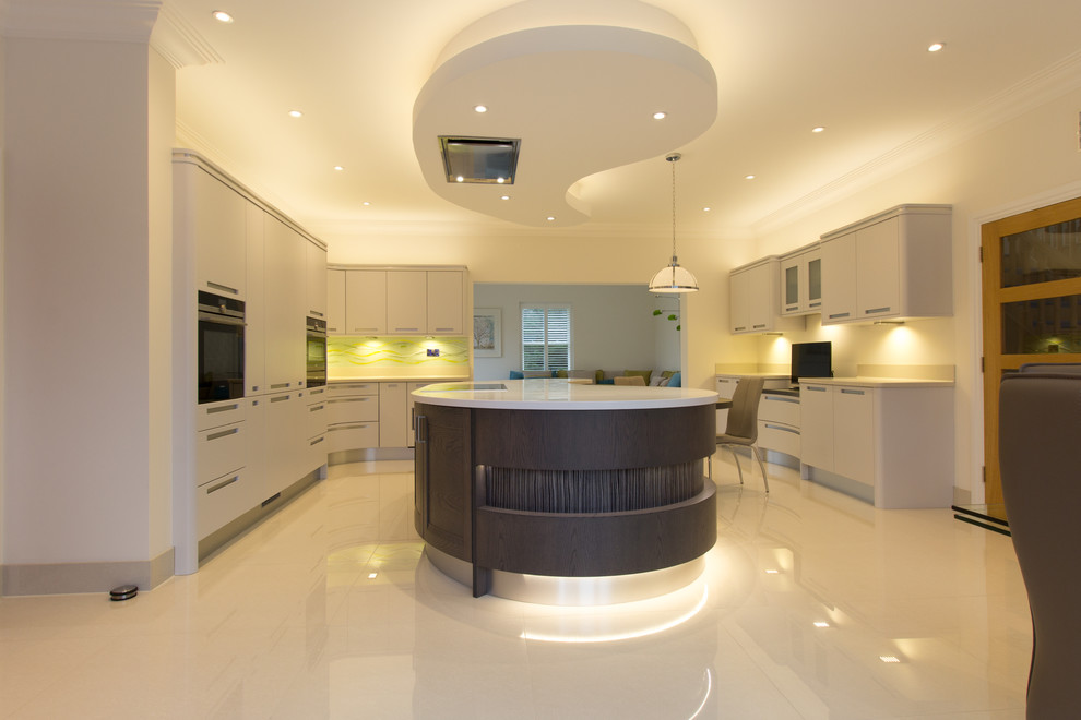 Источник вдохновения для домашнего уюта: кухня-гостиная в стиле неоклассика (современная классика) с серыми фасадами, фартуком из стекла и островом