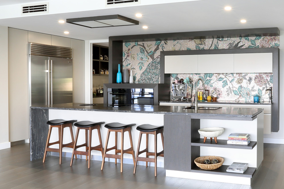 Moderne Küche in U-Form mit flächenbündigen Schrankfronten, weißen Schränken, bunter Rückwand, Rückwand aus Mosaikfliesen, Küchengeräten aus Edelstahl, dunklem Holzboden und Kücheninsel in Brisbane