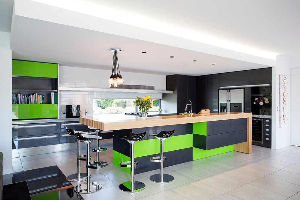 Photo of a large contemporary galley kitchen/diner in Christchurch with a submerged sink, flat-panel cabinets, black cabinets, wood worktops, stainless steel appliances, ceramic flooring, an island and grey floors.