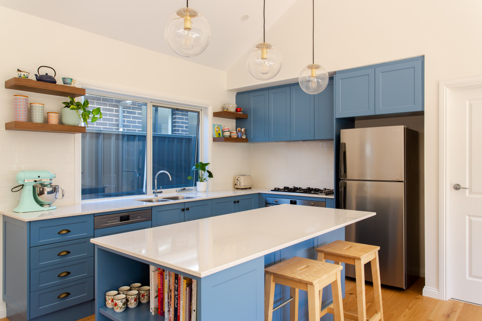 Mittelgroße Klassische Küche in L-Form mit Doppelwaschbecken, blauen Schränken, Küchenrückwand in Weiß, Küchengeräten aus Edelstahl und Kücheninsel in Adelaide