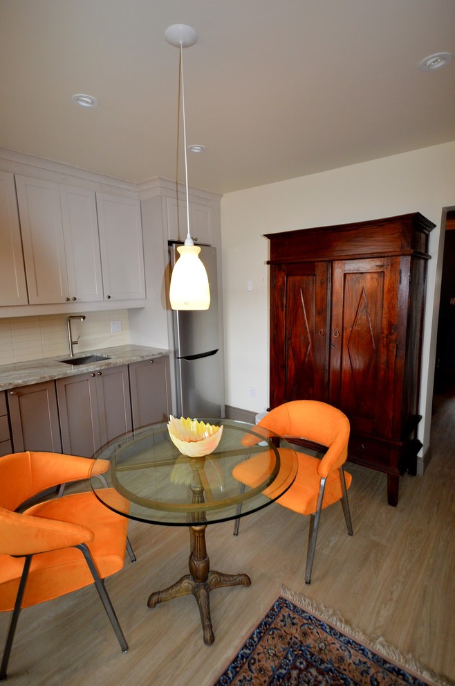 Bild på ett mellanstort eklektiskt linjärt kök och matrum, med en undermonterad diskho, skåp i shakerstil, grå skåp, granitbänkskiva, gult stänkskydd, stänkskydd i keramik, rostfria vitvaror, en köksö och beiget golv