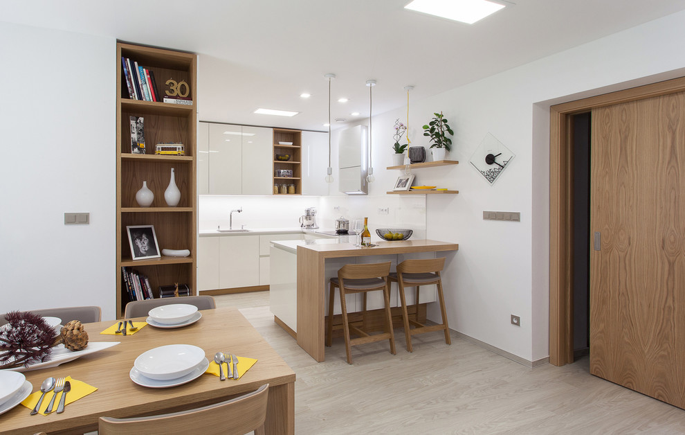 Стильный дизайн: п-образная кухня-гостиная в современном стиле с светлым паркетным полом, плоскими фасадами, белыми фасадами и полуостровом - последний тренд