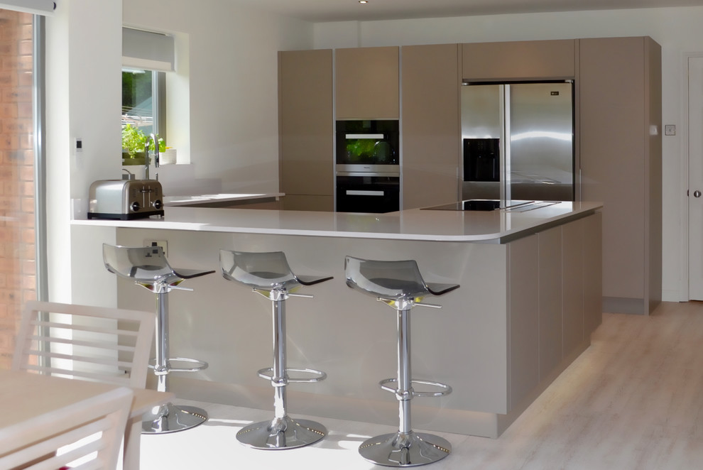Mittelgroße Moderne Wohnküche ohne Insel in U-Form mit Quarzit-Arbeitsplatte, Küchengeräten aus Edelstahl, Vinylboden und flächenbündigen Schrankfronten in West Midlands
