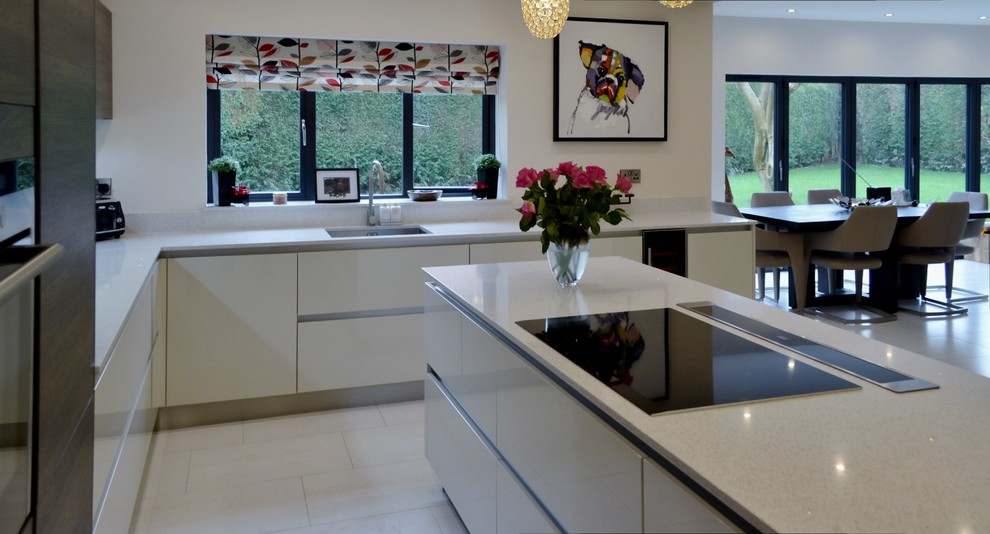 Inspiration for a contemporary l-shaped kitchen/diner in West Midlands with stainless steel appliances and an island.