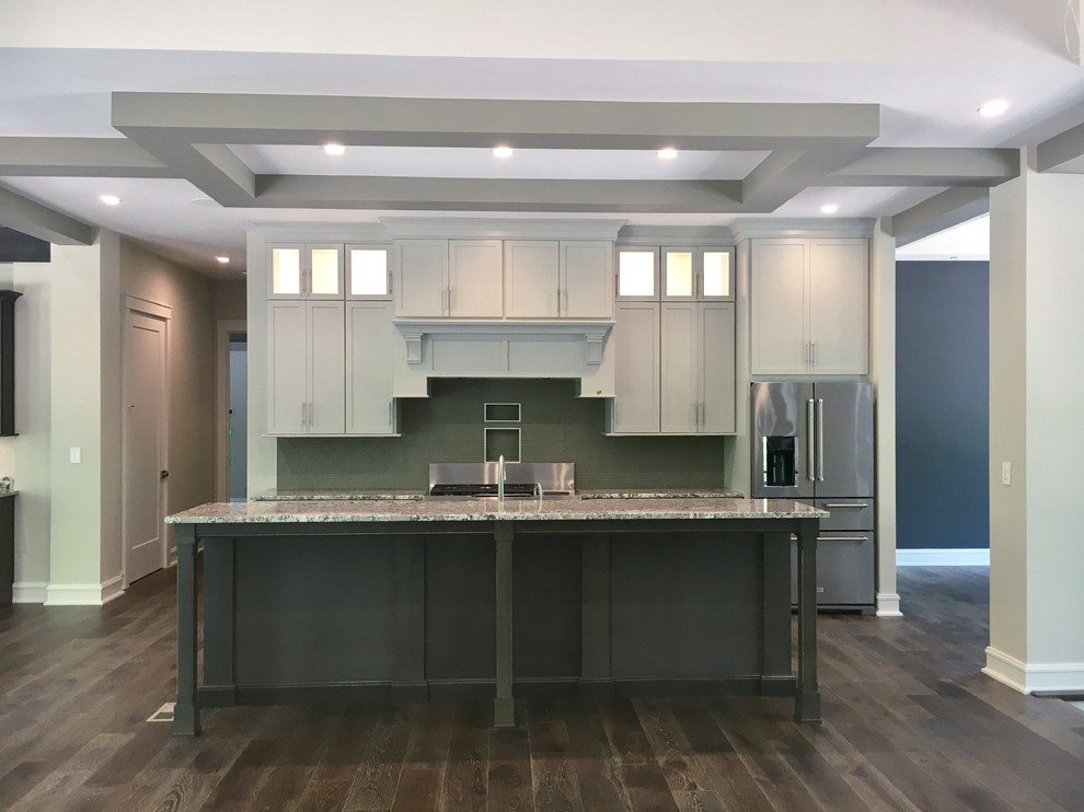 Design ideas for a large traditional kitchen/diner in Other with a belfast sink, flat-panel cabinets, grey cabinets, granite worktops, grey splashback, glass tiled splashback, stainless steel appliances and an island.