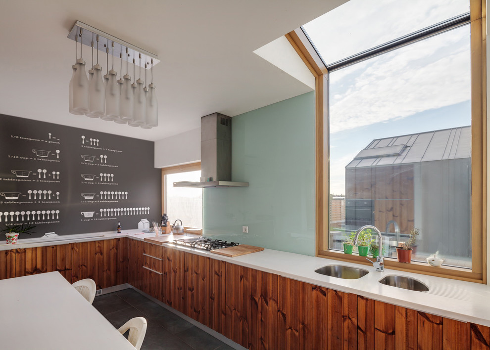 Trendy l-shaped enclosed kitchen photo in Other with an undermount sink, medium tone wood cabinets and glass sheet backsplash