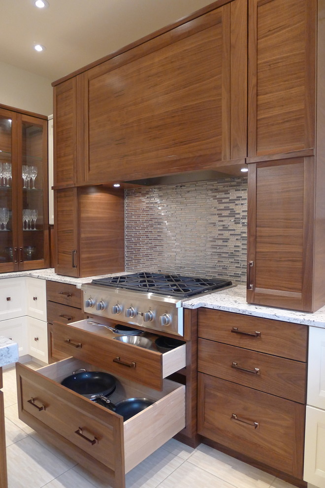 Photo of a medium sized contemporary u-shaped kitchen in Indianapolis with granite worktops, a submerged sink, recessed-panel cabinets, medium wood cabinets, metallic splashback, metal splashback, stainless steel appliances and ceramic flooring.