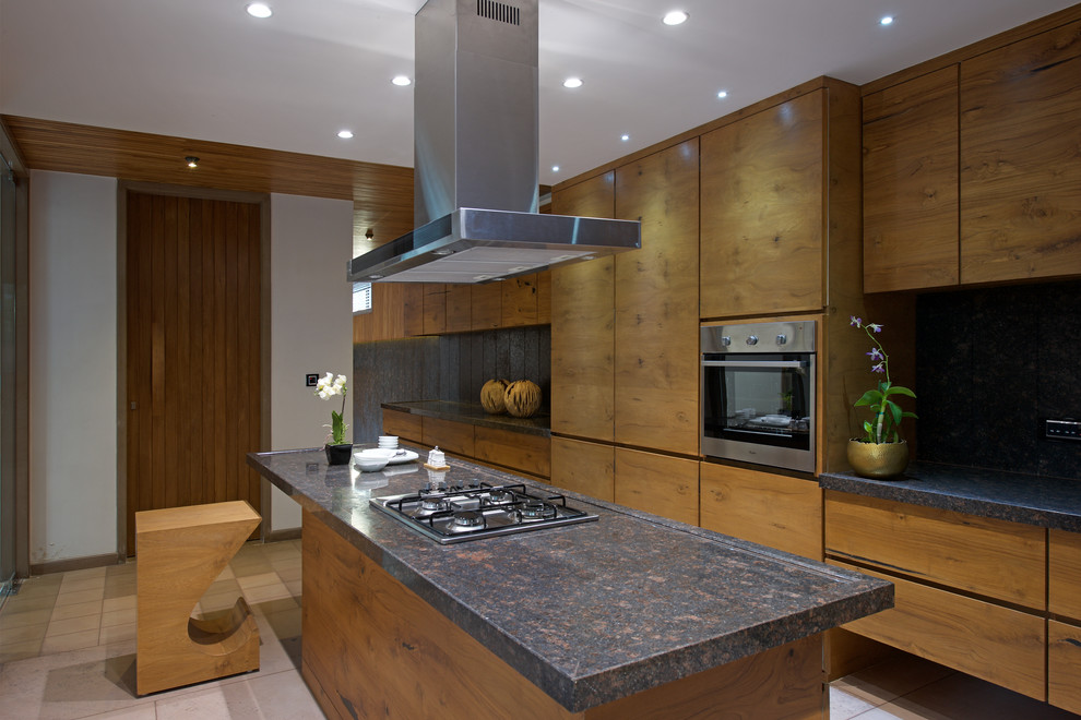 アフマダーバードにある広いアジアンスタイルのおしゃれなキッチン (フラットパネル扉のキャビネット、茶色いキャビネット、シルバーの調理設備、ベージュの床、茶色いキッチンカウンター) の写真