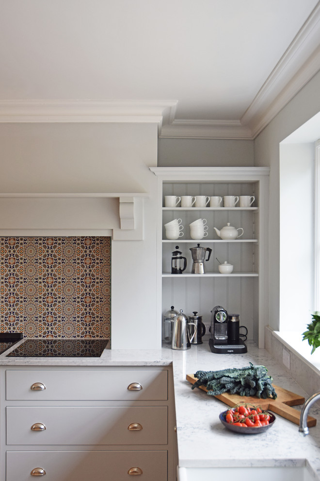 Bild på ett stort vintage grå grått kök, med en dubbel diskho, skåp i shakerstil, vita skåp, bänkskiva i kvarts, grått stänkskydd, stänkskydd i sten, rostfria vitvaror, mellanmörkt trägolv, en köksö och brunt golv