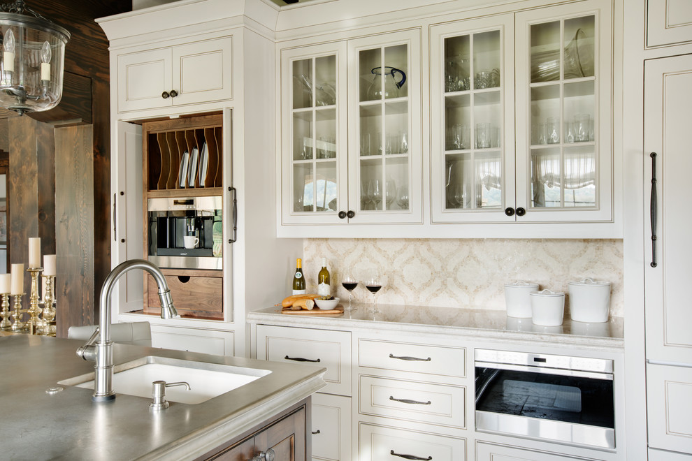 Example of a large tuscan u-shaped limestone floor eat-in kitchen design in Other with a farmhouse sink, shaker cabinets, beige cabinets, quartzite countertops, beige backsplash, mosaic tile backsplash, stainless steel appliances and an island