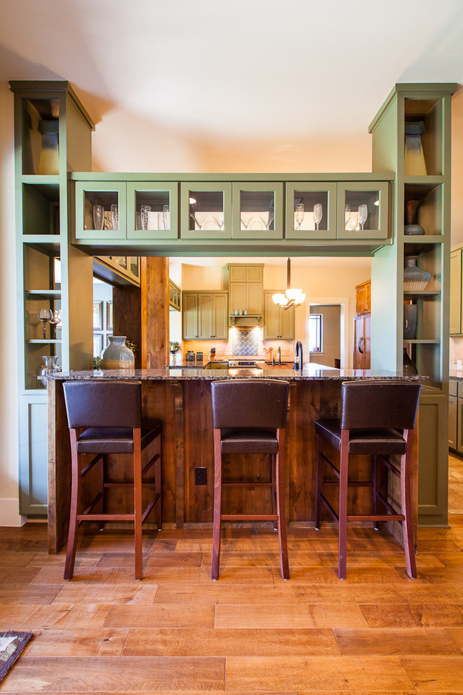 Imagen de cocina actual con encimera de granito, puertas de armario verdes y barras de cocina