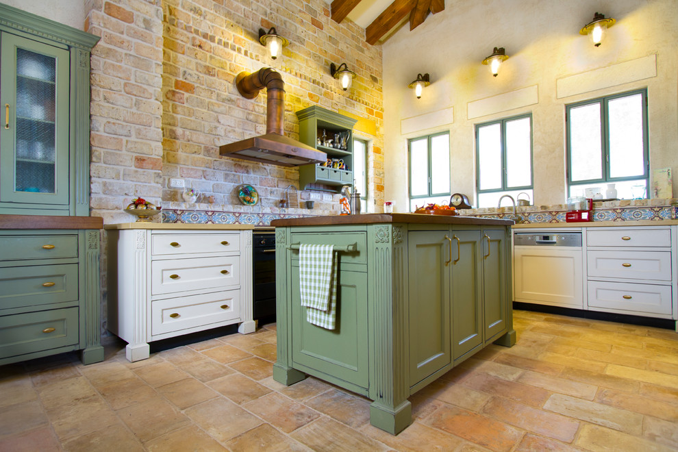 Modelo de cocina tradicional con armarios con paneles empotrados, puertas de armario verdes y salpicadero multicolor
