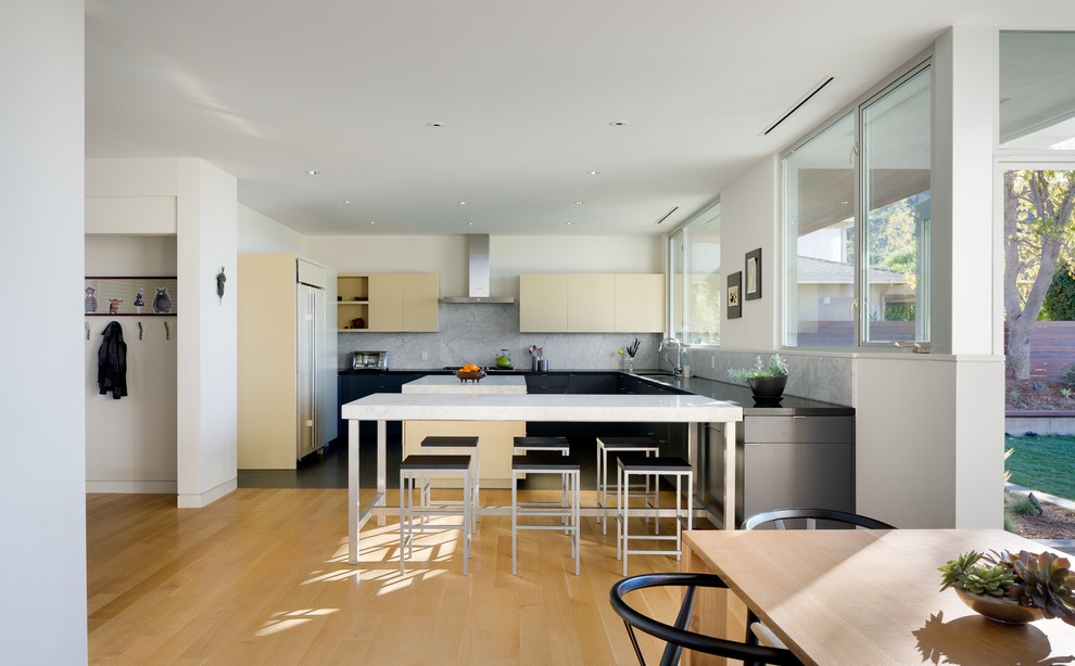 Стильный дизайн: п-образная кухня в современном стиле с плоскими фасадами, бежевыми фасадами и островом - последний тренд