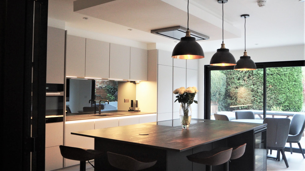 На фото: отдельная, угловая кухня среднего размера в стиле модернизм с накладной мойкой, плоскими фасадами, серыми фасадами, фартуком цвета металлик, полом из керамогранита, островом, серым полом и коричневой столешницей