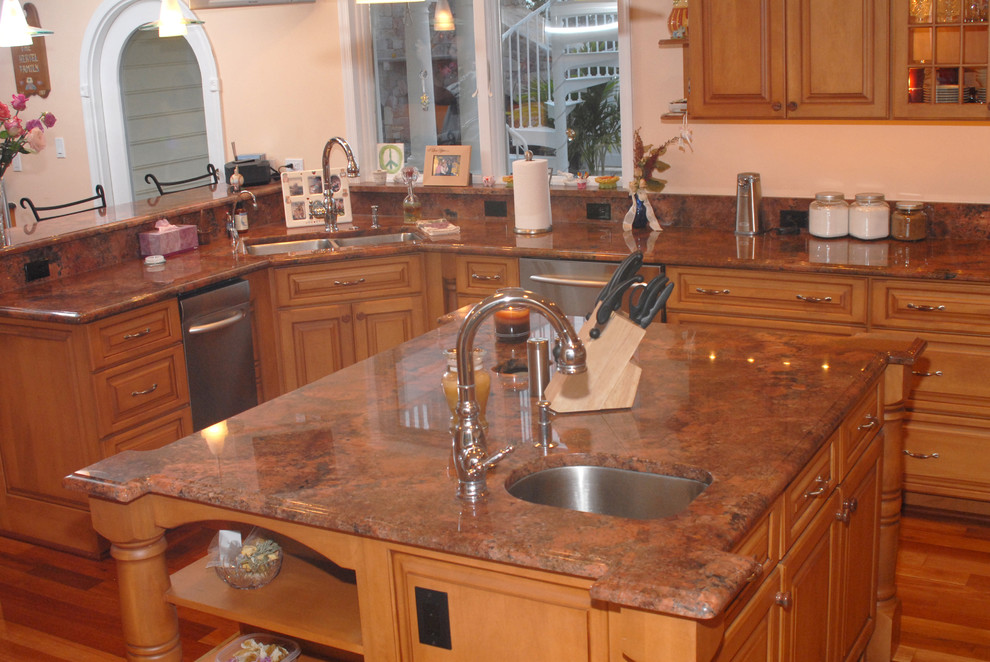 Exempel på ett mellanstort klassiskt kök, med en undermonterad diskho, luckor med upphöjd panel, orange skåp, granitbänkskiva, vitt stänkskydd, stänkskydd i tunnelbanekakel, rostfria vitvaror, ljust trägolv och en köksö