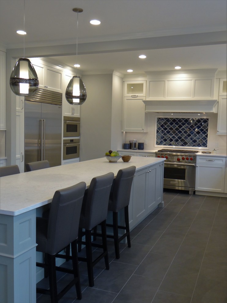 Design ideas for a large classic u-shaped kitchen in DC Metro with a belfast sink, flat-panel cabinets, white cabinets, engineered stone countertops, blue splashback, ceramic splashback, stainless steel appliances, porcelain flooring, an island, grey floors and white worktops.