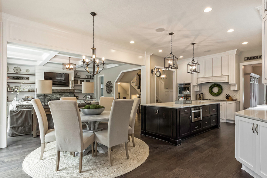Inspiration for a mid-sized transitional l-shaped dark wood floor and brown floor open concept kitchen remodel in Columbus with a farmhouse sink, shaker cabinets, white cabinets, marble countertops, white backsplash, porcelain backsplash, stainless steel appliances and an island