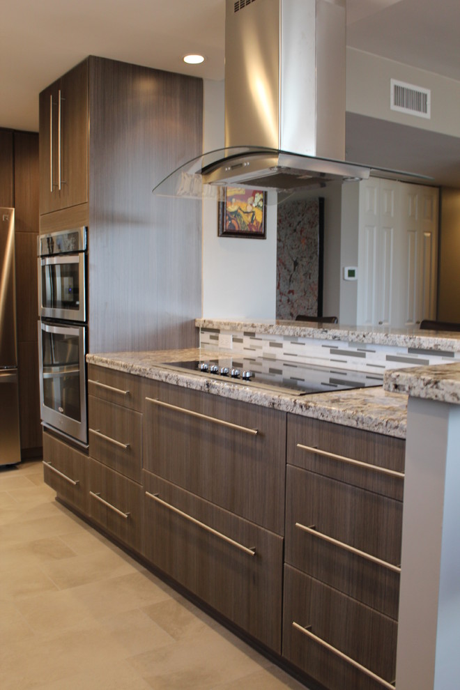 Modern inredning av ett mellanstort kök, med en undermonterad diskho, släta luckor, skåp i mellenmörkt trä, granitbänkskiva, grått stänkskydd, stänkskydd i glaskakel, rostfria vitvaror och klinkergolv i porslin