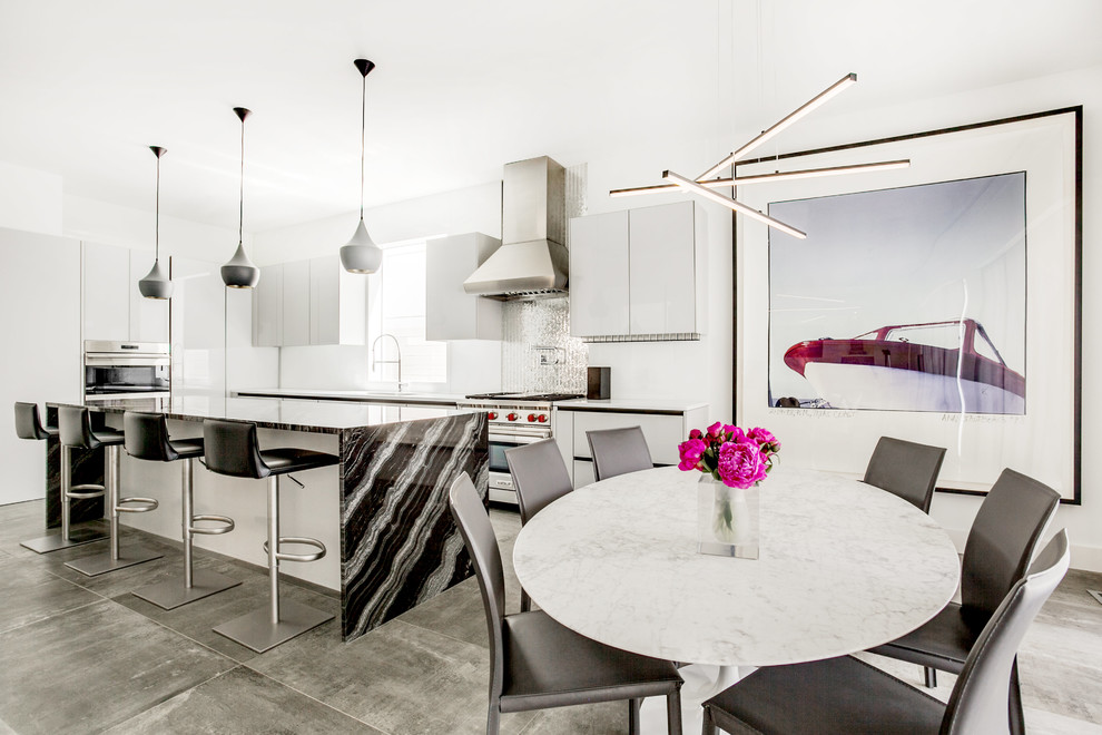 Bild på ett stort funkis kök, med en nedsänkt diskho, luckor med glaspanel, grå skåp, marmorbänkskiva, vitt stänkskydd, glaspanel som stänkskydd, rostfria vitvaror, betonggolv, en köksö och grått golv