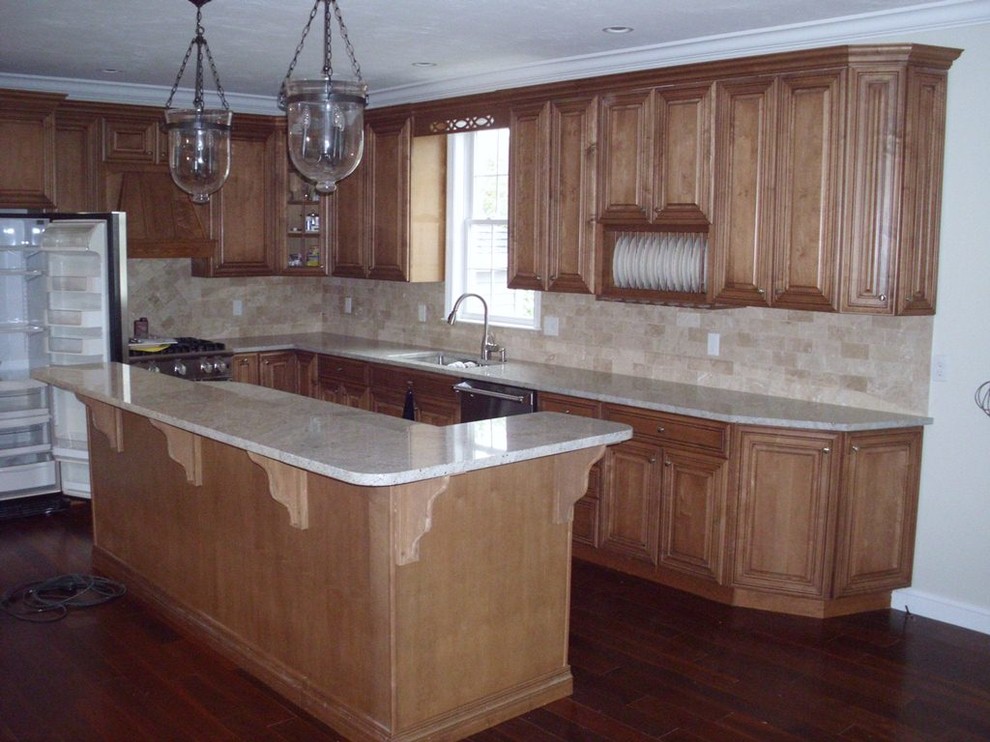 Esempio di una cucina di medie dimensioni con lavello sottopiano, ante con bugna sagomata, ante in legno scuro, top in granito, paraspruzzi beige, elettrodomestici in acciaio inossidabile e parquet scuro
