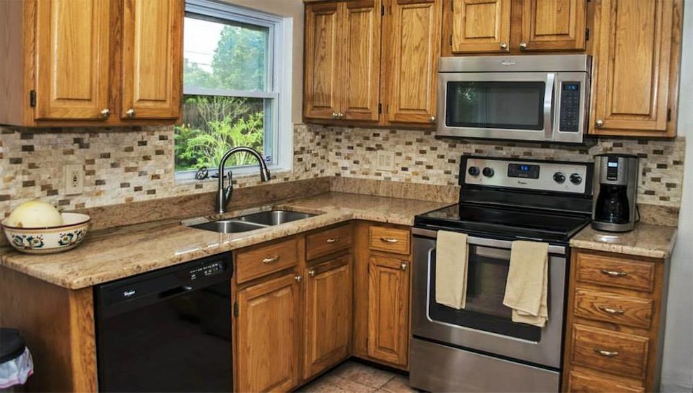 This is an example of a small traditional l-shaped kitchen in Tampa with a submerged sink, raised-panel cabinets, medium wood cabinets, granite worktops, multi-coloured splashback and stainless steel appliances.