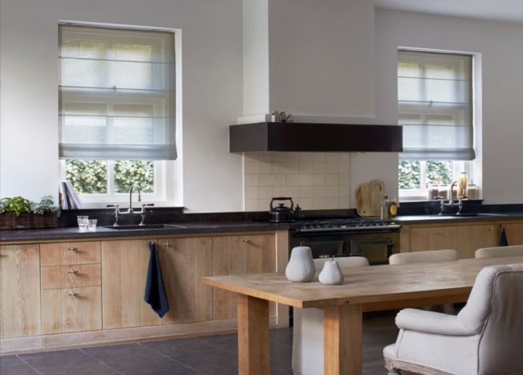 This is an example of a large contemporary single-wall kitchen/diner in New York with a submerged sink, flat-panel cabinets, light wood cabinets, soapstone worktops, white splashback, ceramic splashback, black appliances, slate flooring, no island and grey floors.