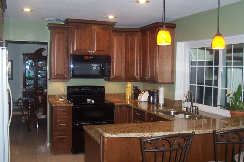 Example of a small transitional kitchen design in Tampa with beaded inset cabinets, medium tone wood cabinets and granite countertops