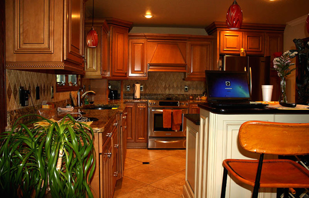 Klassische Küche mit hellbraunen Holzschränken, Granit-Arbeitsplatte, Küchenrückwand in Beige, Küchengeräten aus Edelstahl und Kücheninsel in Little Rock